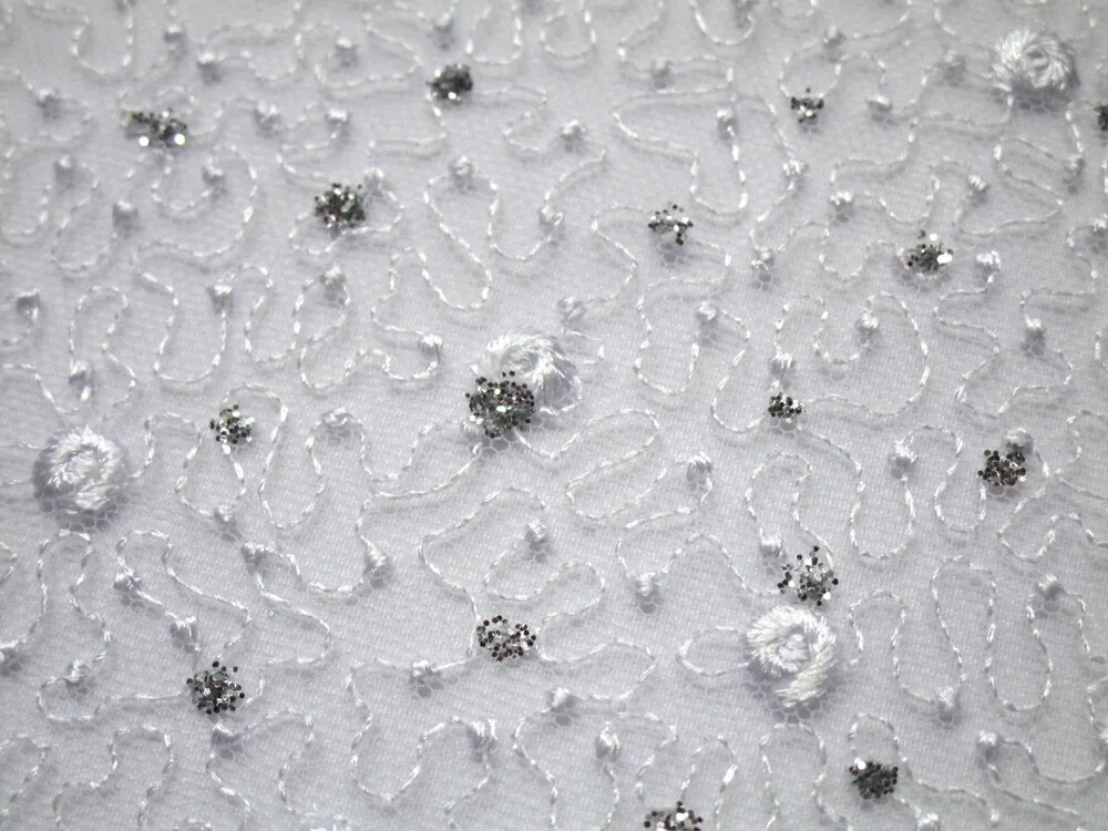 Vyšívaný tyl biely "biely kvet, vlnovky, strieborné glitre"